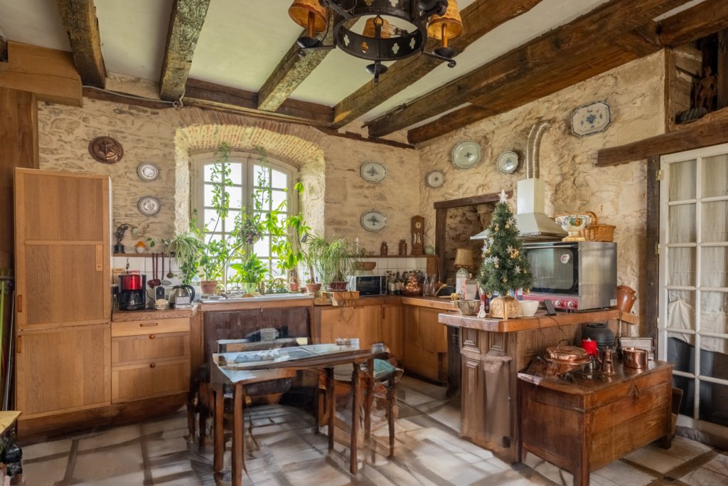 The large granite vaulted fireplace suggests that this room once served as a kitchen. A doorway with a broken arch reveals the remnants of an ...